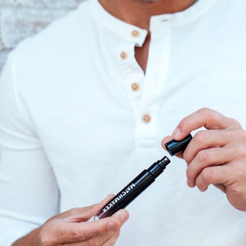 Mann öffnet schwarzen Stift. Aufschrift: MATCHMAKER. Schwarze Kappe. Weißes Hemd mit Knöpfen.