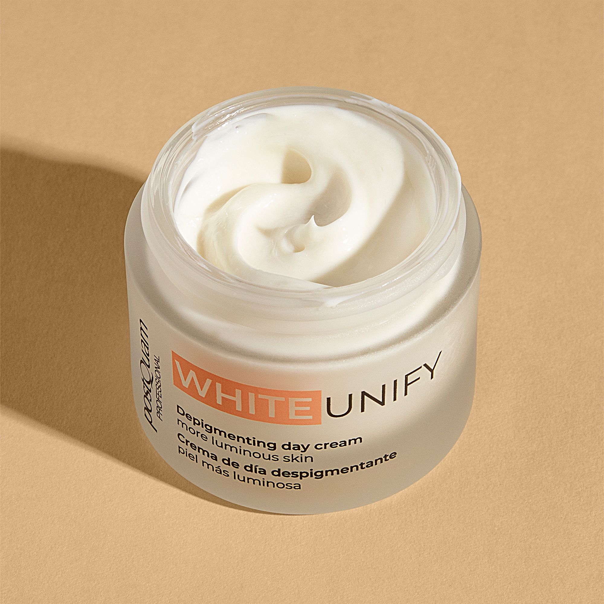 Geöffneter Creme-Tiegel. Weiße Creme sichtbar. Aufschrift WHITE UNIFY, Depigmenting day cream, mehr leuchtende Haut. Marke Postquam.