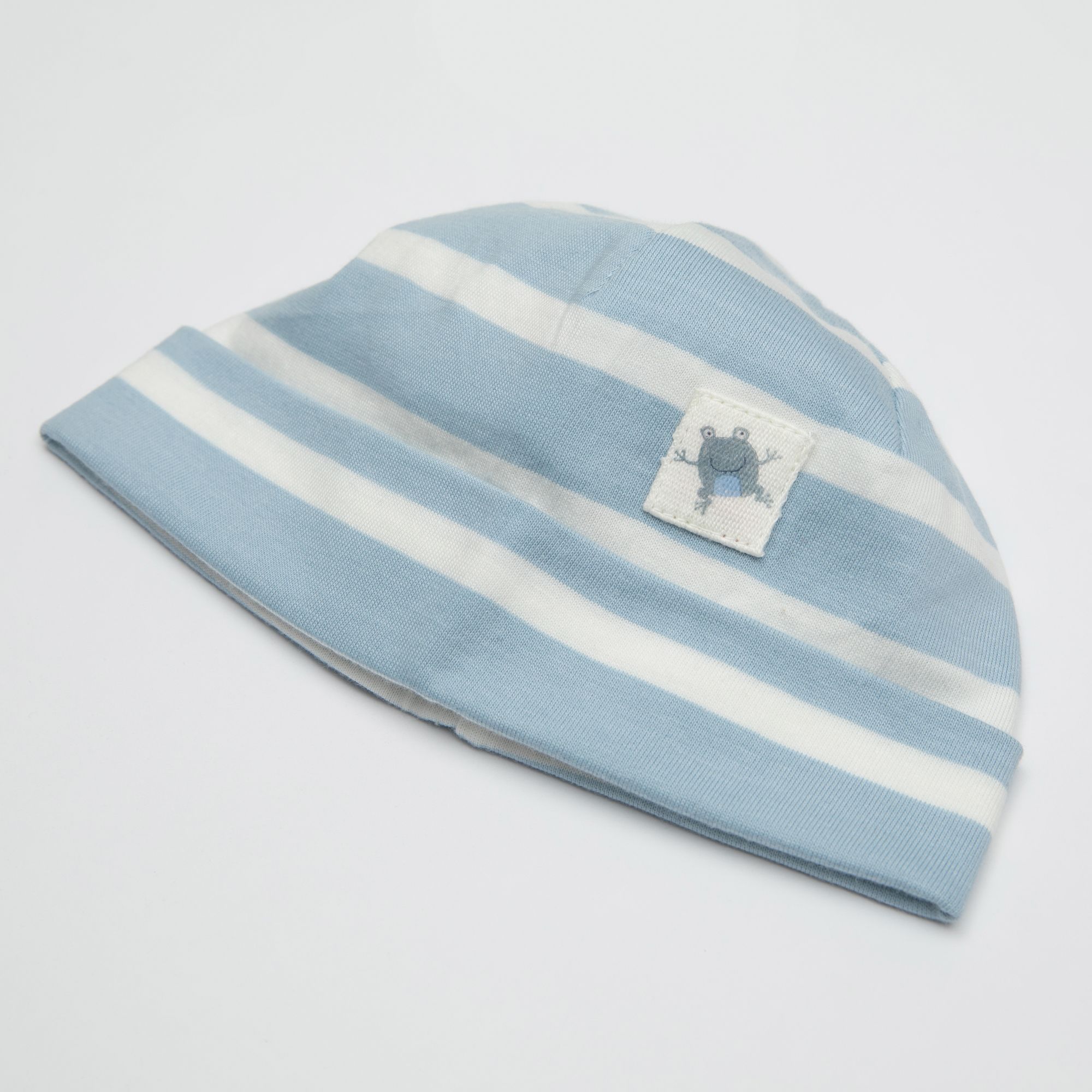 Hellblau-weiß gestreifte Mütze mit quadratischem Aufnäher. Aufnäher zeigt ein blaues Tier. Einfache Form.