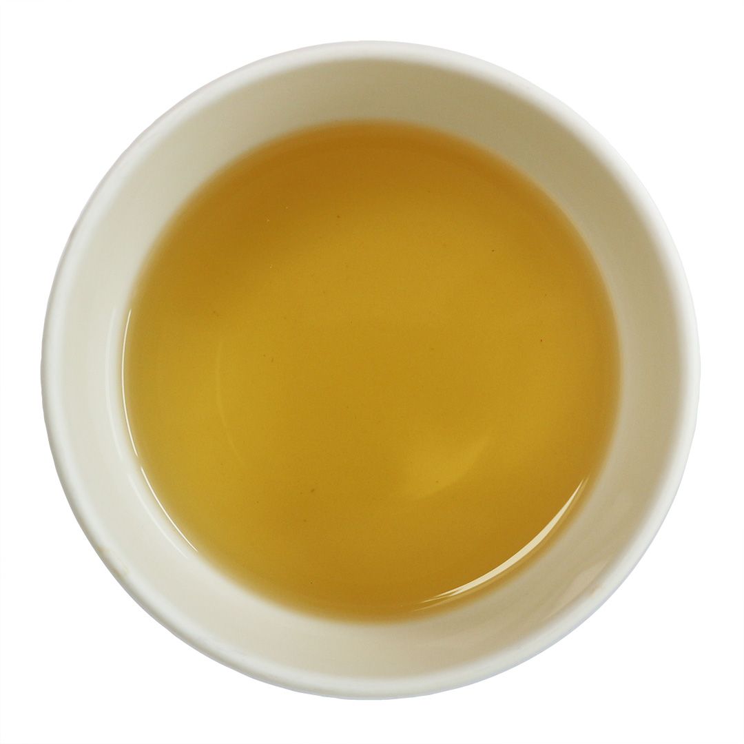 Weiße Schale mit gelbem Tee. Draufsicht.