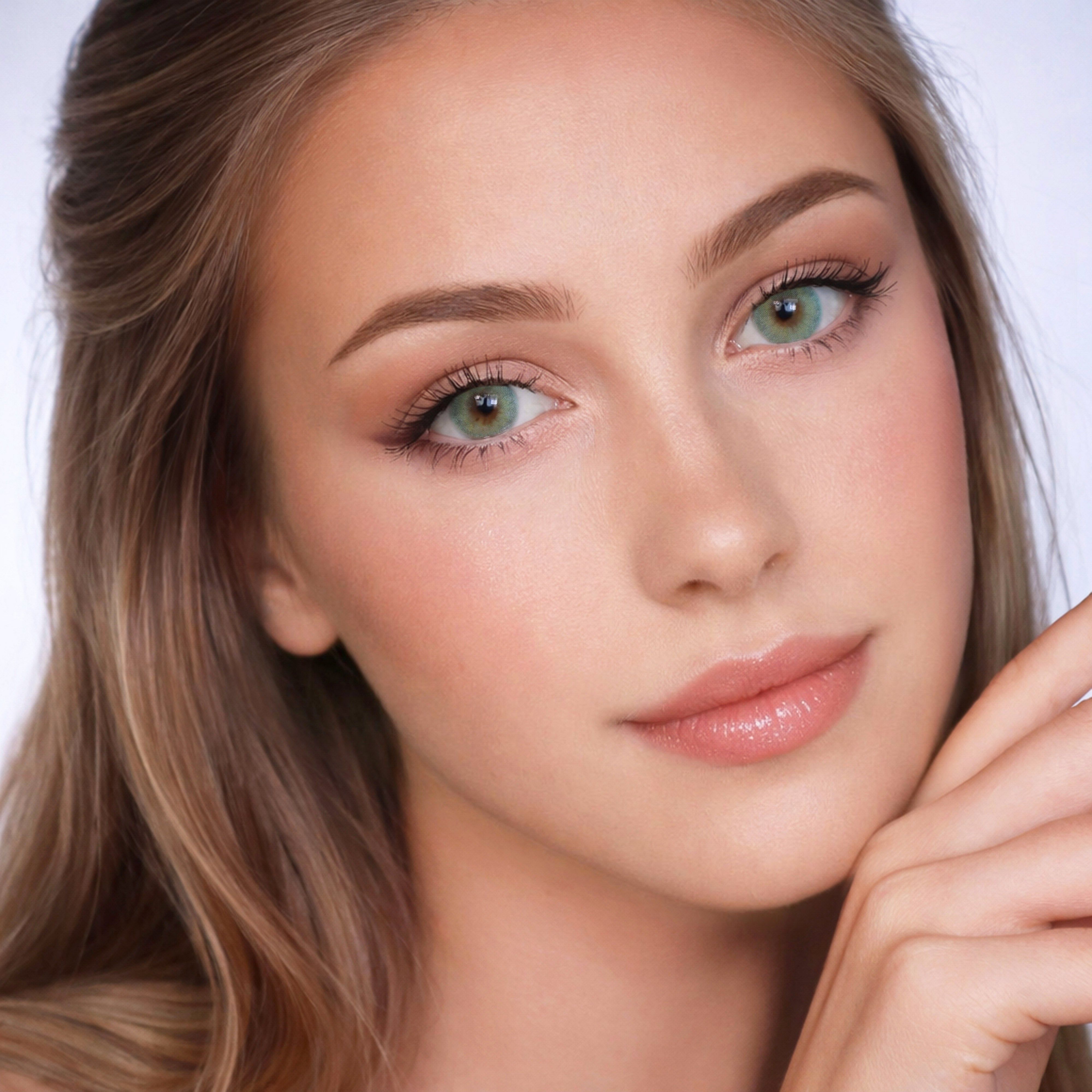 Porträt einer Frau mit lindgrünen Kontaktlinsen. Helle Haut, lange Haare, Make-up.