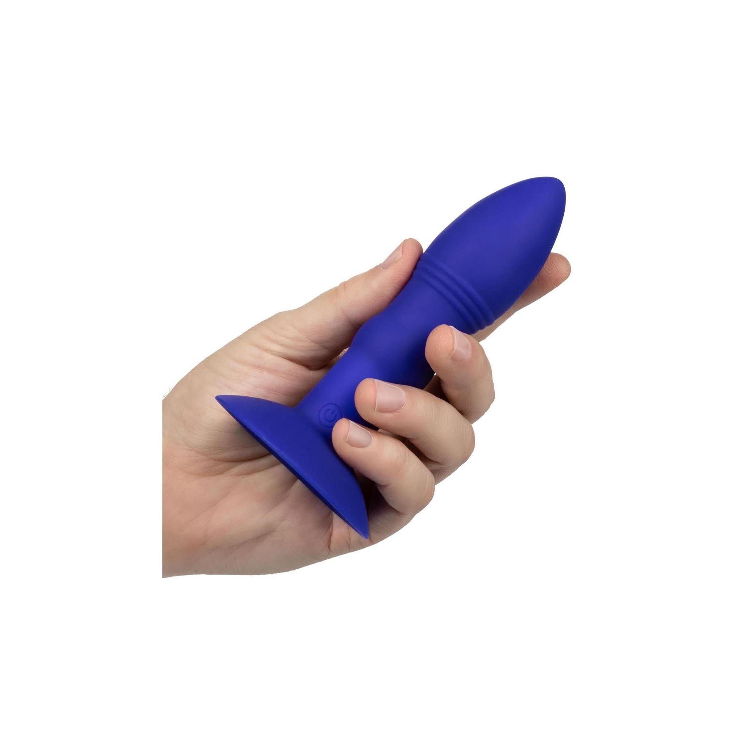 Hand hält blauen Anal-Stimulator. Kegelförmiger Kopf, geriffelter Schaft, flache Basis. Auf weißem Hintergrund.