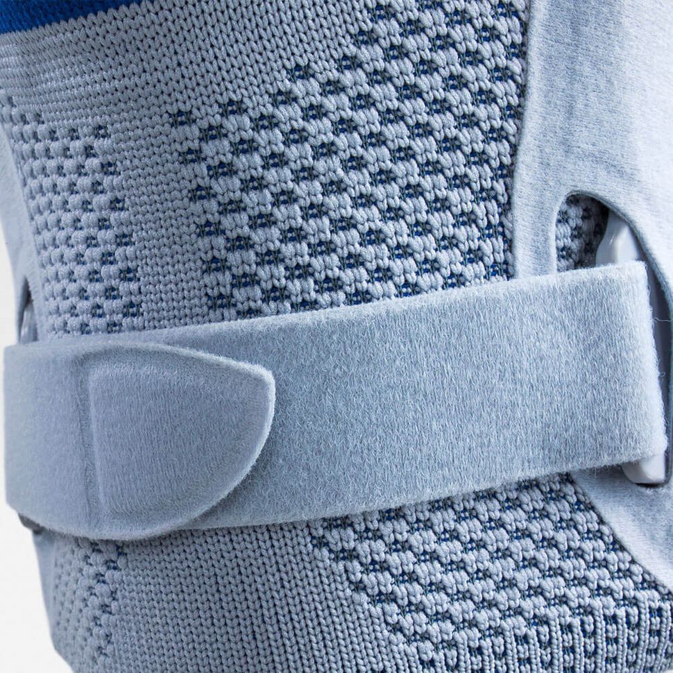 Nahaufnahme einer blauen und weißen Kniebandage mit einem grauen Klettverschluss.