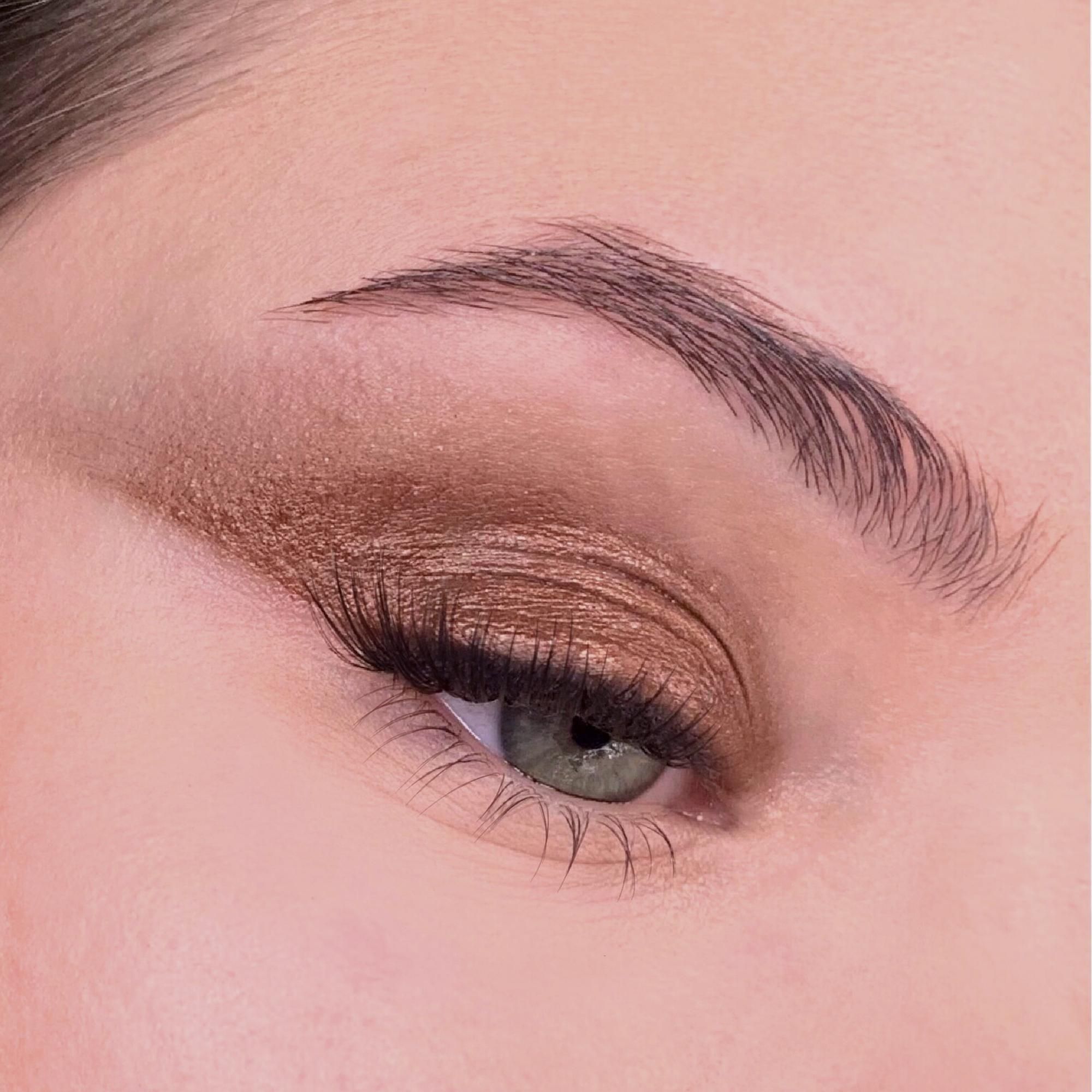 Nahaufnahme eines geschminkten Auges. Braune Lidschatten. Braue und Wimpern.