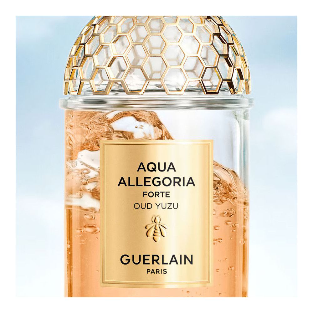 Glasflakon mit goldfarbenem Etikett. Aufschrift: Aqua Allegoria Forte Oud Yuzu, Guerlain. Goldfarbener Deckel.