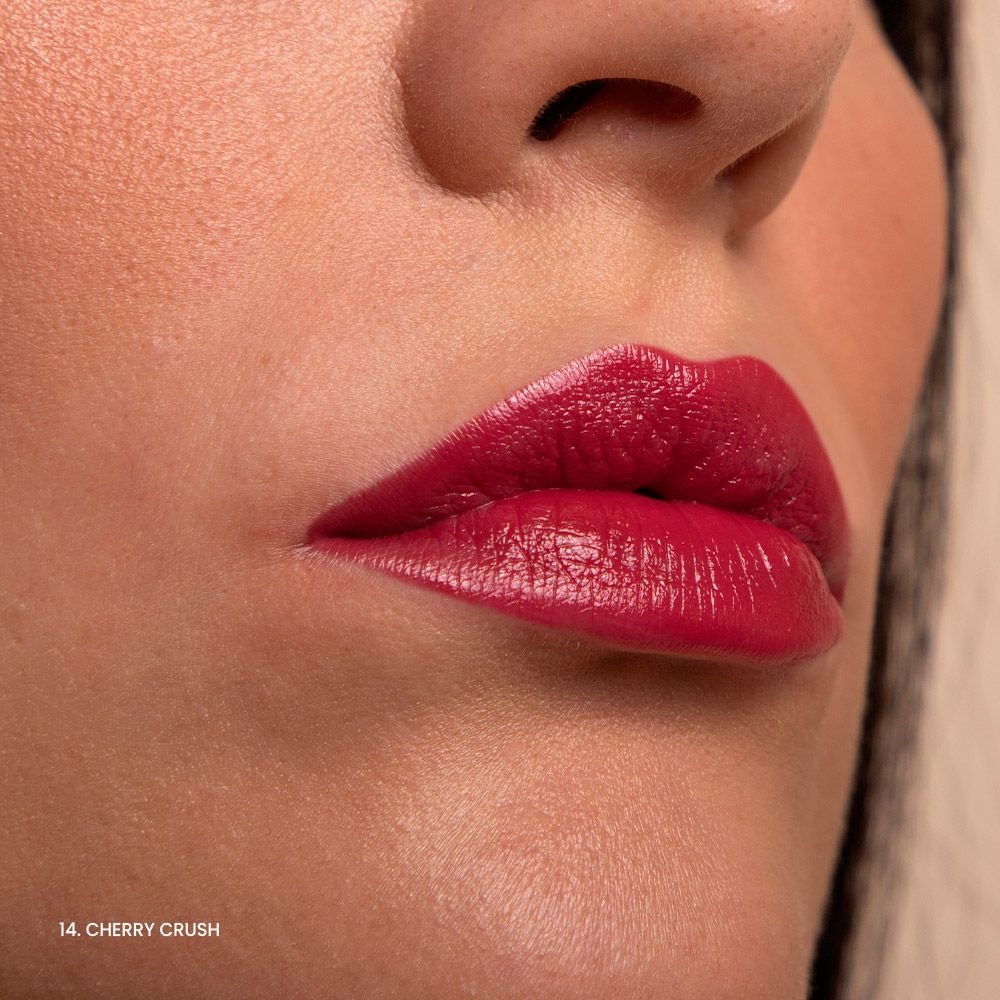 Primo piano di labbra con rossetto rosso lucido. Sotto le labbra, "14. Cherry Crush".