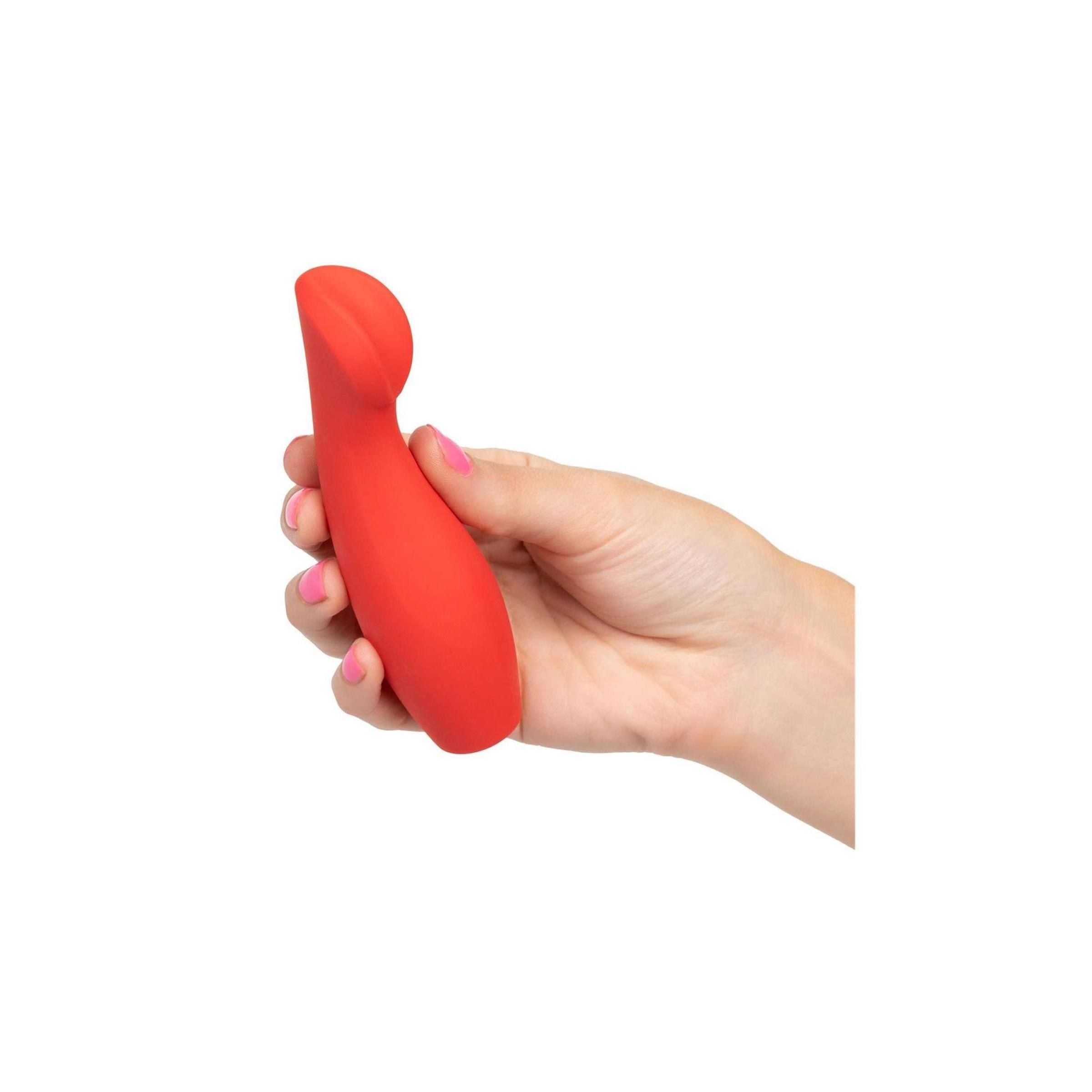 Roter Vibrator in einer Hand gehalten. Rosa lackierte Fingernägel. Produkt im Gebrauch dargestellt.
