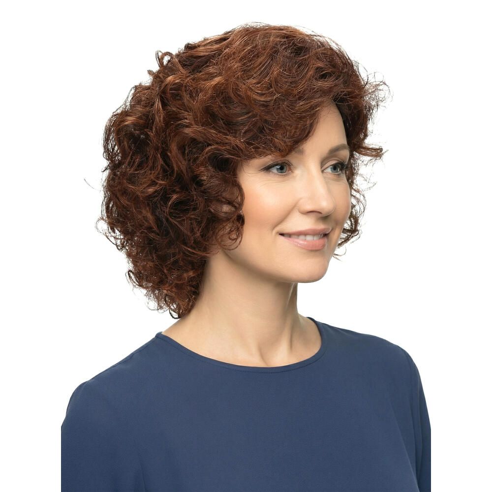 Frau mit brauner Perücke mit Locken, Dreiviertelansicht. Sie trägt ein blaues Oberteil. Weißer Hintergrund.