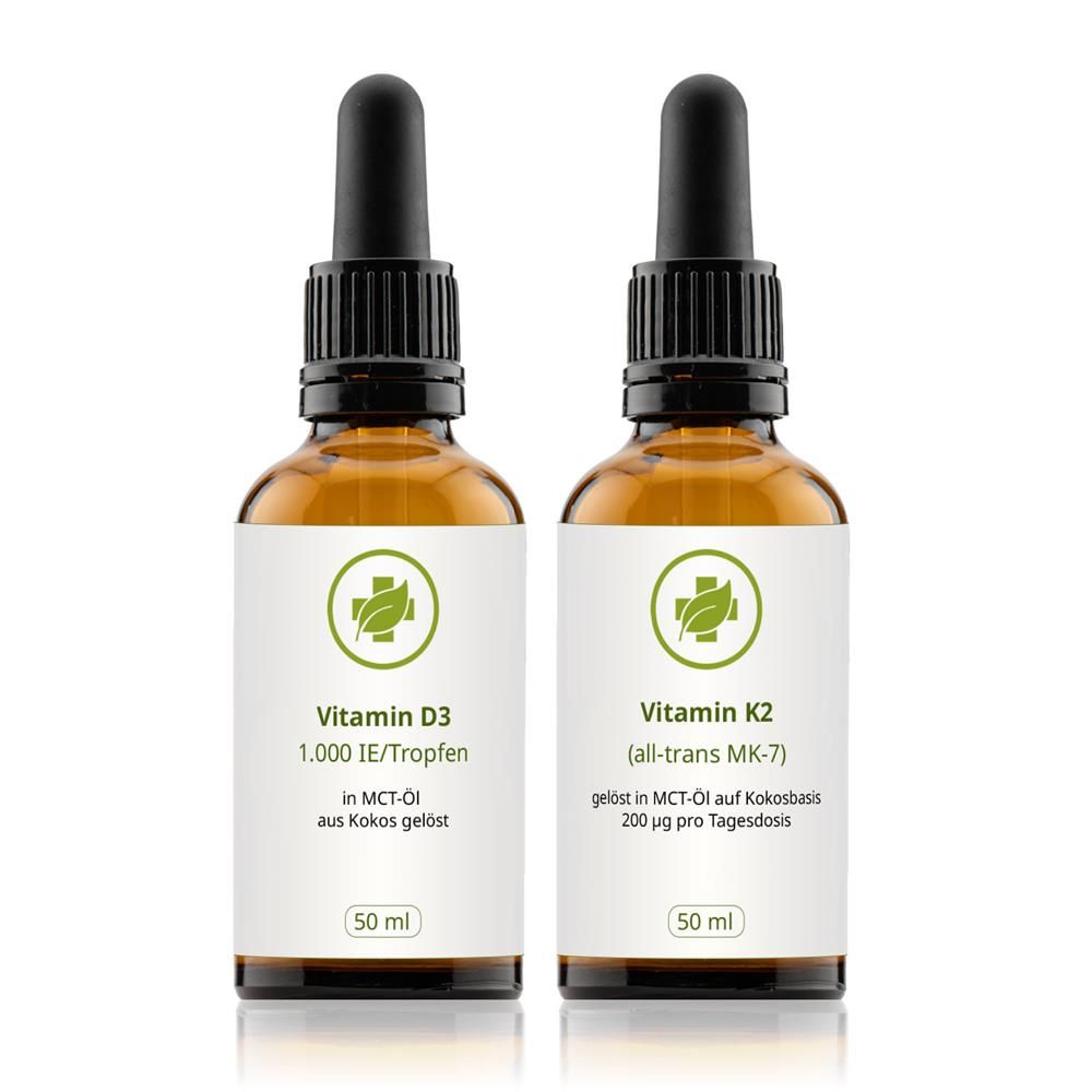 Zwei braune Glasflaschen mit schwarzen Pipetten. Etiketten mit grünen Kreuzen und Text: Vitamin D3 und Vitamin K2. 50 ml.