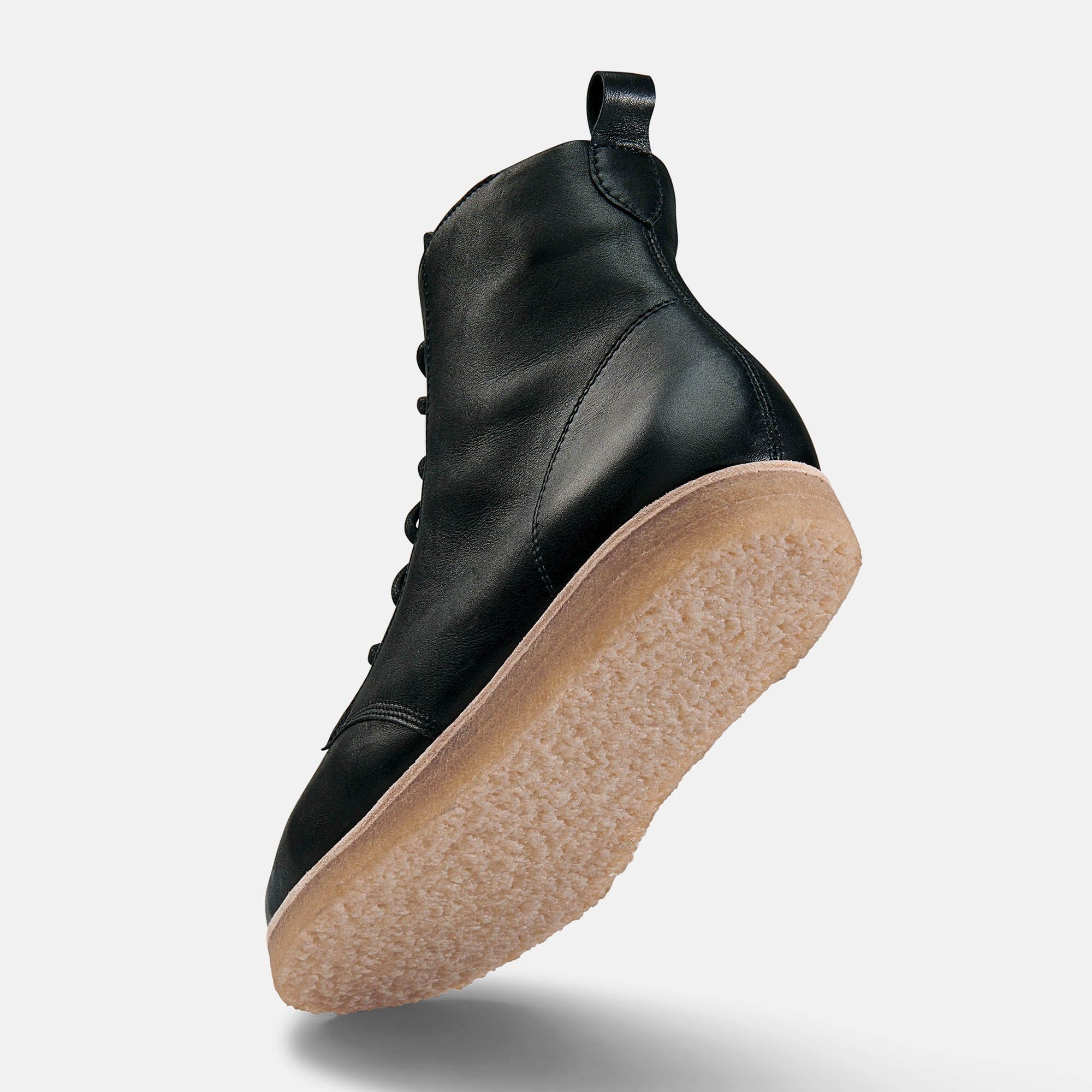 Schwarze Stiefelette mit Schnürung und heller Sohle. Schuh von unten gesehen.