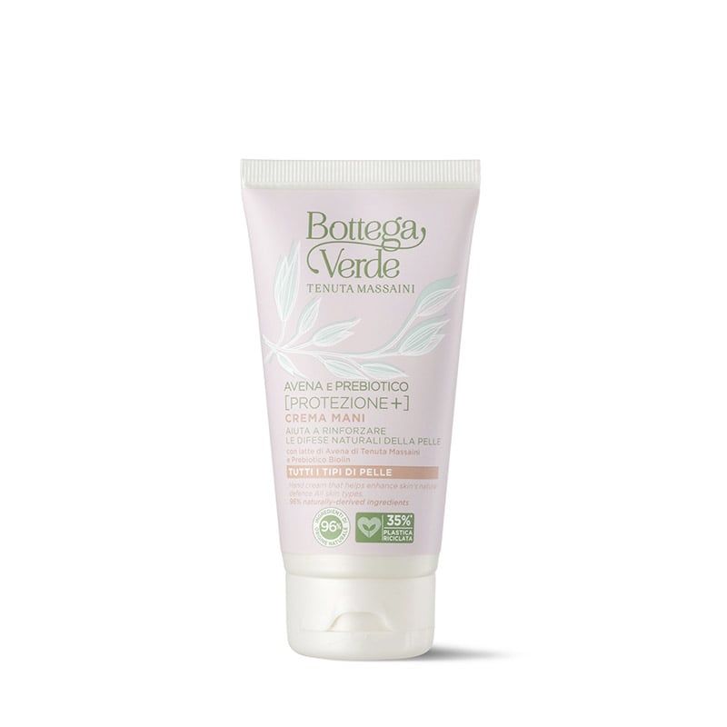 Tubo di crema mani Bottega Verde Avena e Prebiotico [Protezione+]. L'imballaggio rosa presenta elementi verdi. Sono visibili il nome del prodotto e gli ingredienti. Loghi indicano ingredienti naturali e materiali riciclati.