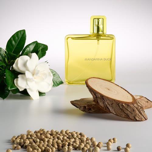 Gelbes Eau de Toilette Spray. Flasche mit Blumen und Holzstücken. Schriftzug Mandarina Duck.