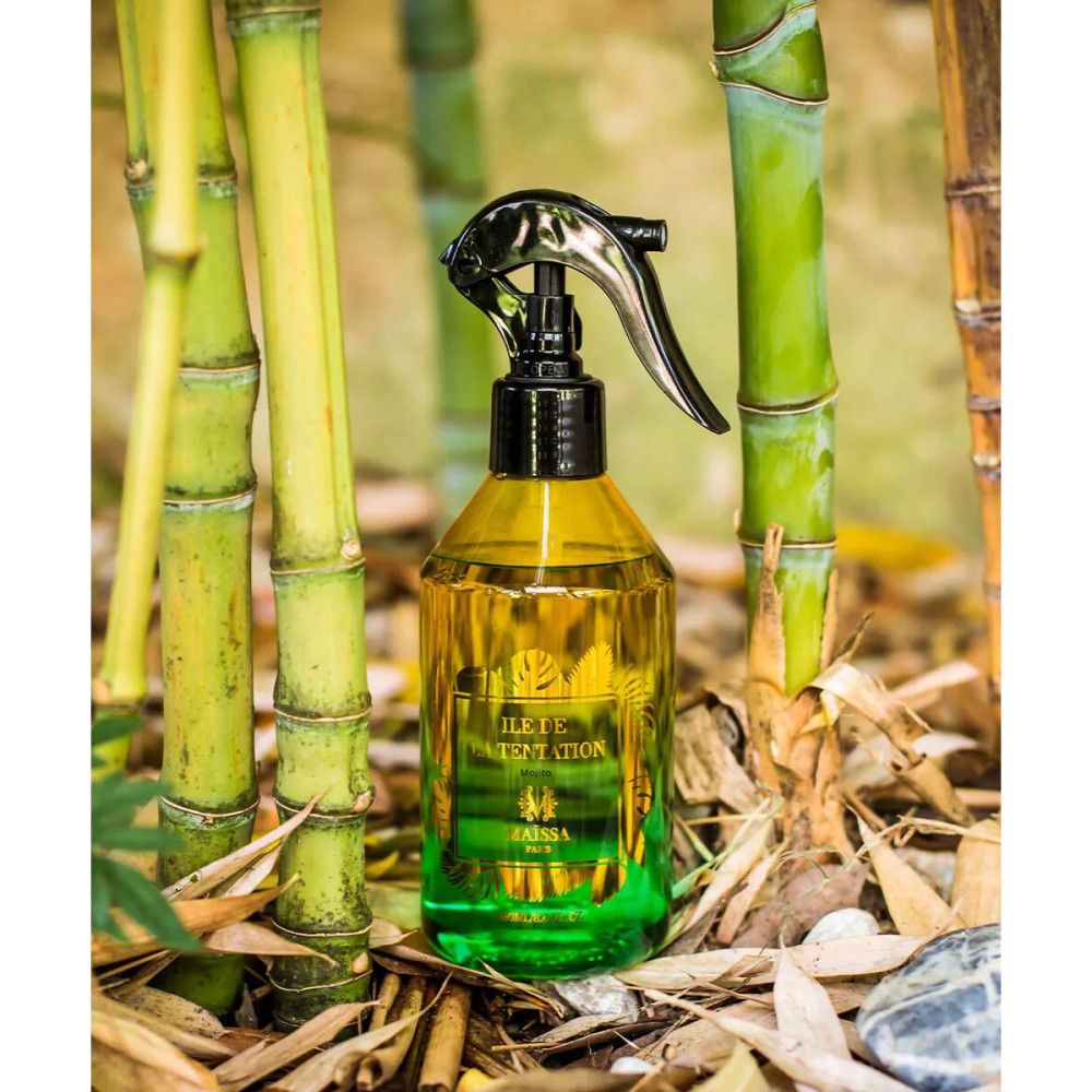 Grüne und gelbe Flüssigkeit in Sprühflasche. Schwarzer Sprühkopf. Aufschrift: ÎLE DE LA TENTATION, MAÏSSA. Bambus im Hintergrund.