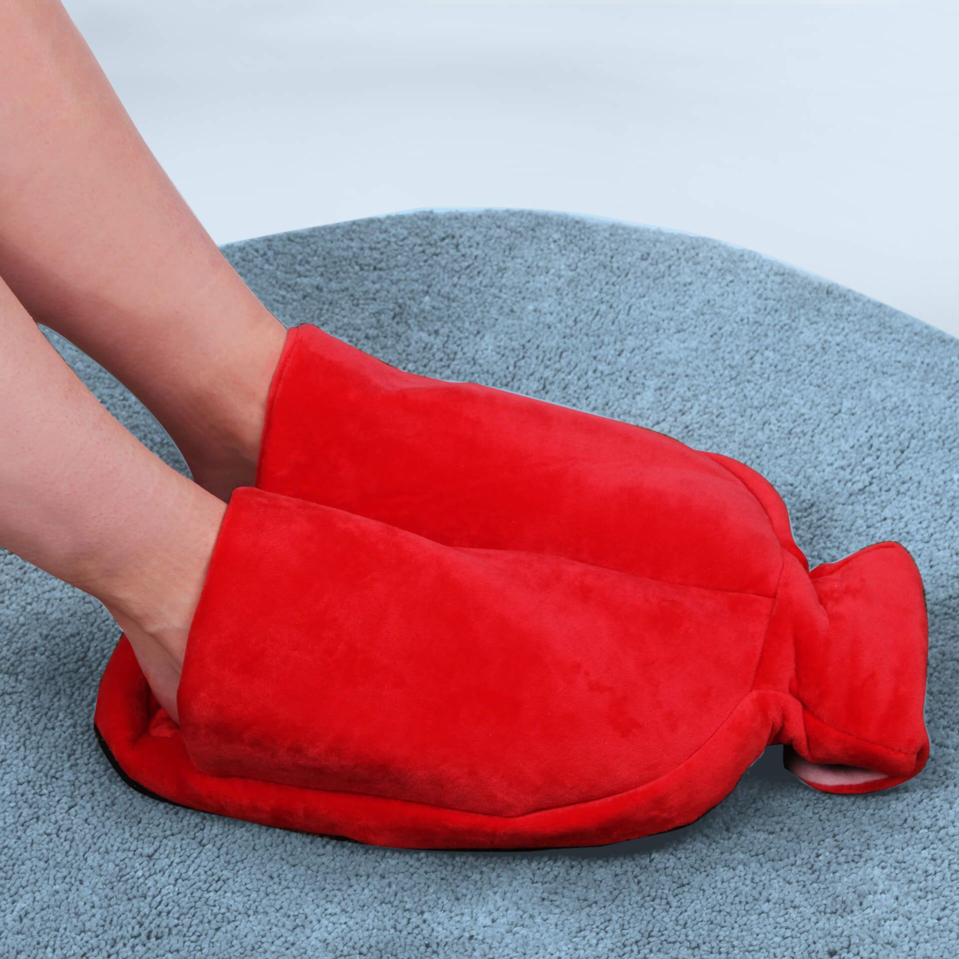 Füße in rotem Fleece-Fußwärmer. Weiches Material, zwei Fußöffnungen. Auf blauem Untergrund.