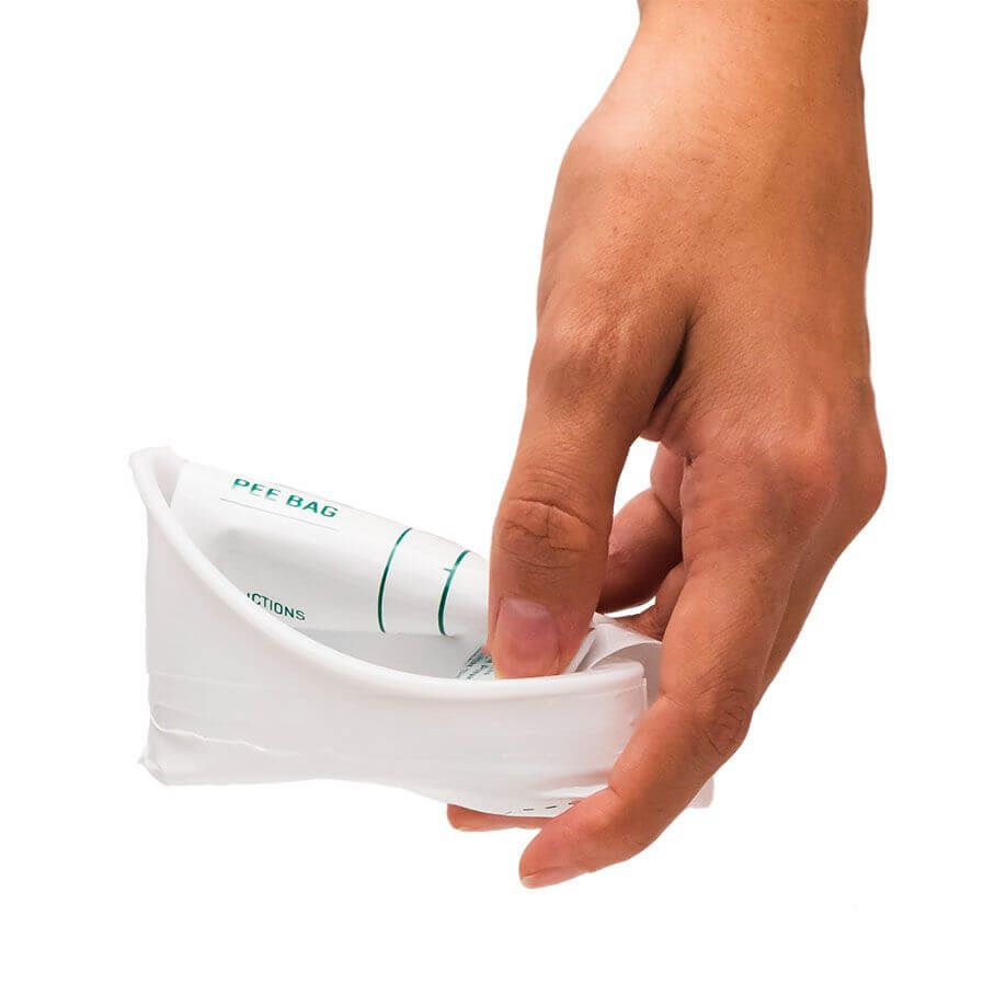 Hand hält einen weißen Auffangbehälter mit einem Pinkelbeutel. Der Beutel ist in der Halterung.