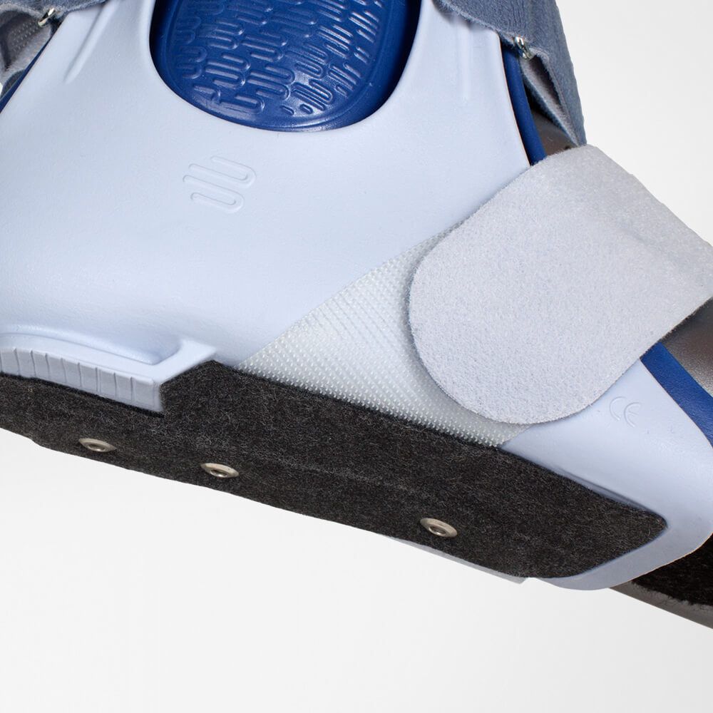 Knöchelorthese, weiß-blau. Klettverschluss, grauer Filz an der Sohle. Details der Konstruktion.