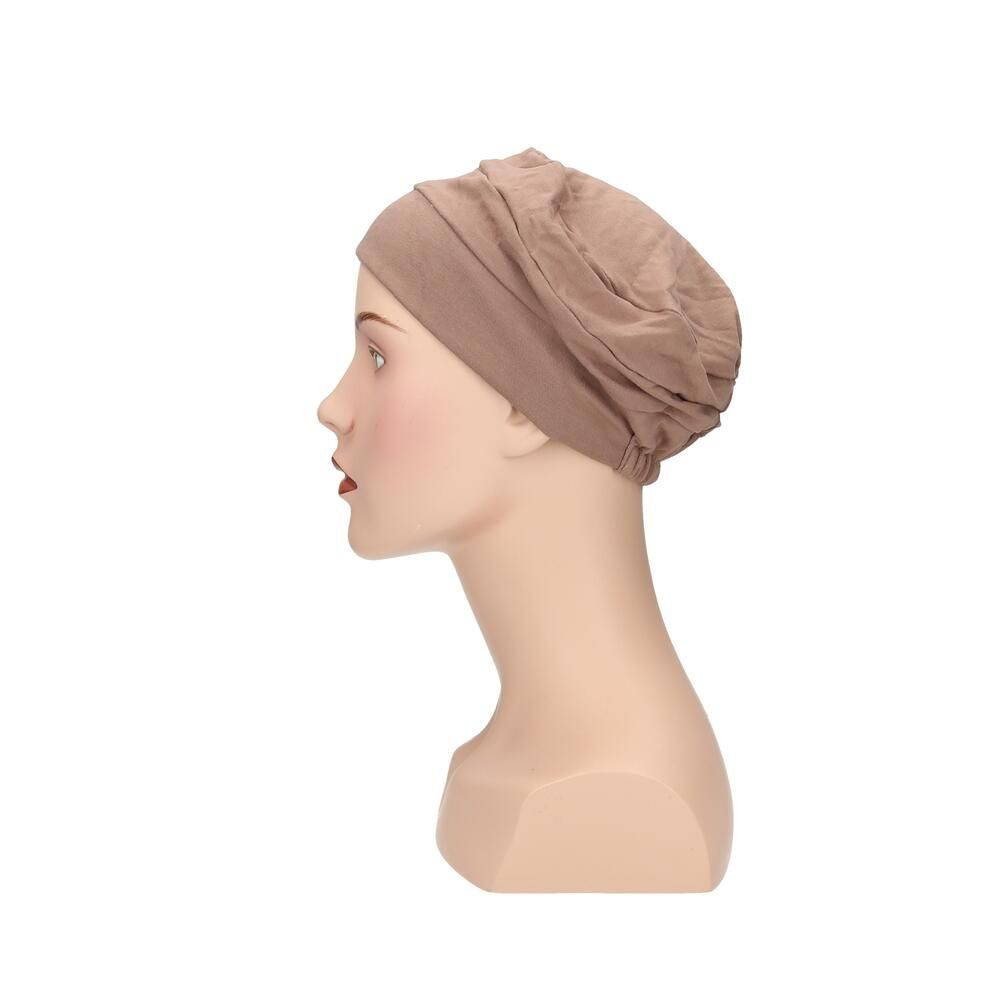 Beigefarbener Turban auf einer Schaufensterpuppe. Seitenansicht.