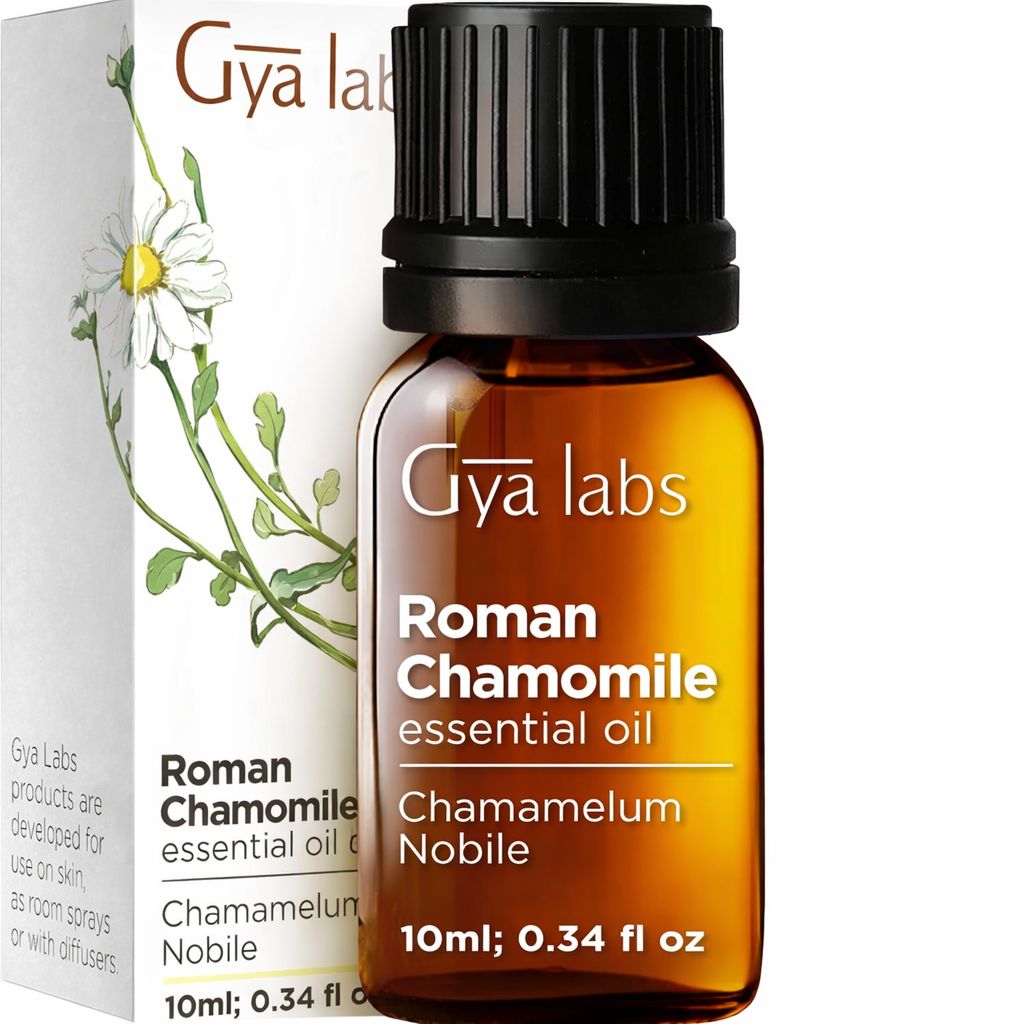 Braune Glasflasche mit schwarzem Deckel. Etikett: Gya Labs, Römische Kamille, 10ml. Verpackung mit Kamille.