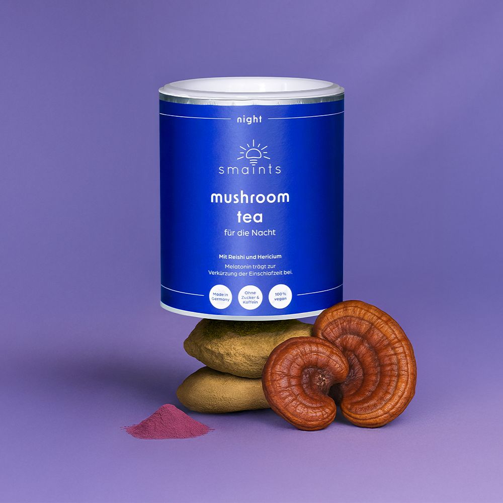 Blaue Dose mit Text: smaints mushroom tea für die Nacht. Daneben Reishi-Pilze, Pulver und Steine.