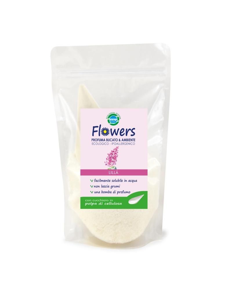 Confezione di "Flowers Profuma Bucato & Ambiente" in polvere. L'etichetta indica "Lilla". Facilmente solubile in acqua, non lascia grumi e rilascia un profumo. Include un cucchiaio in polpa di cellulosa.