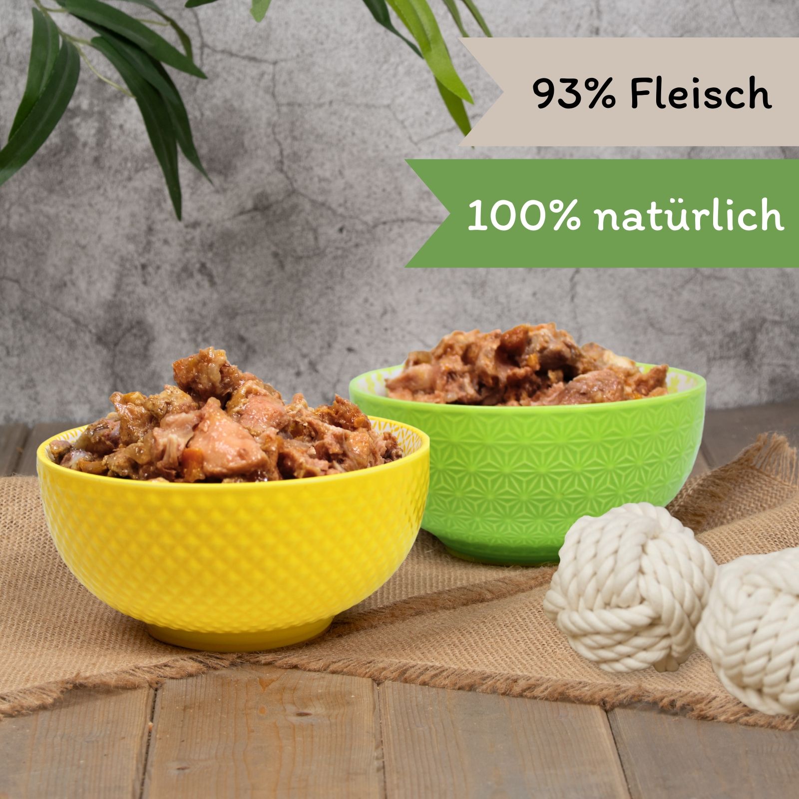 Zwei Schüsseln Hundefutter. Aufschrift: 93% Fleisch, 100% natürlich. Gelbe und grüne Schüssel.