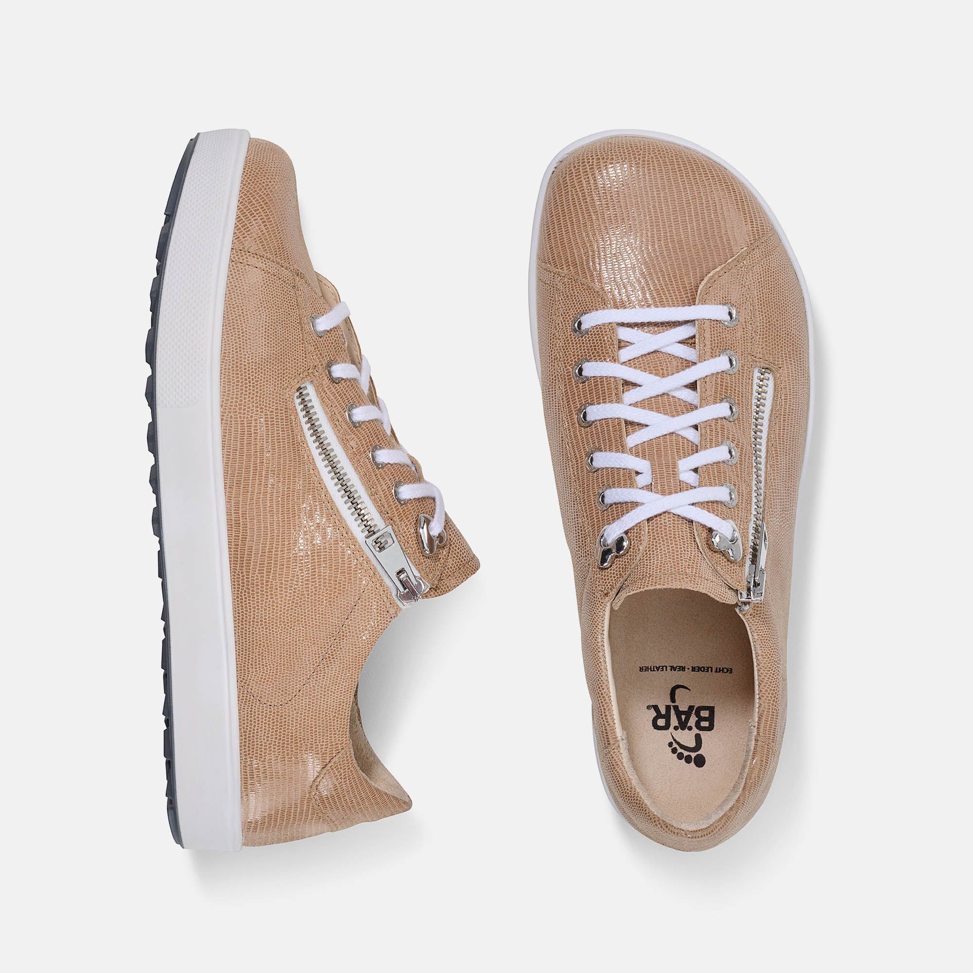 Zwei beige Schnürschuhe mit weißer Sohle und Reißverschluss. Schnürsenkel weiß. Blick von oben.