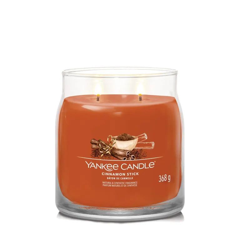 Glasbehälter mit orangefarbenem Wachs. Aufschrift: Yankee Candle, Cinnamon Stick, 368 g. Abbildung von Zimtstangen.