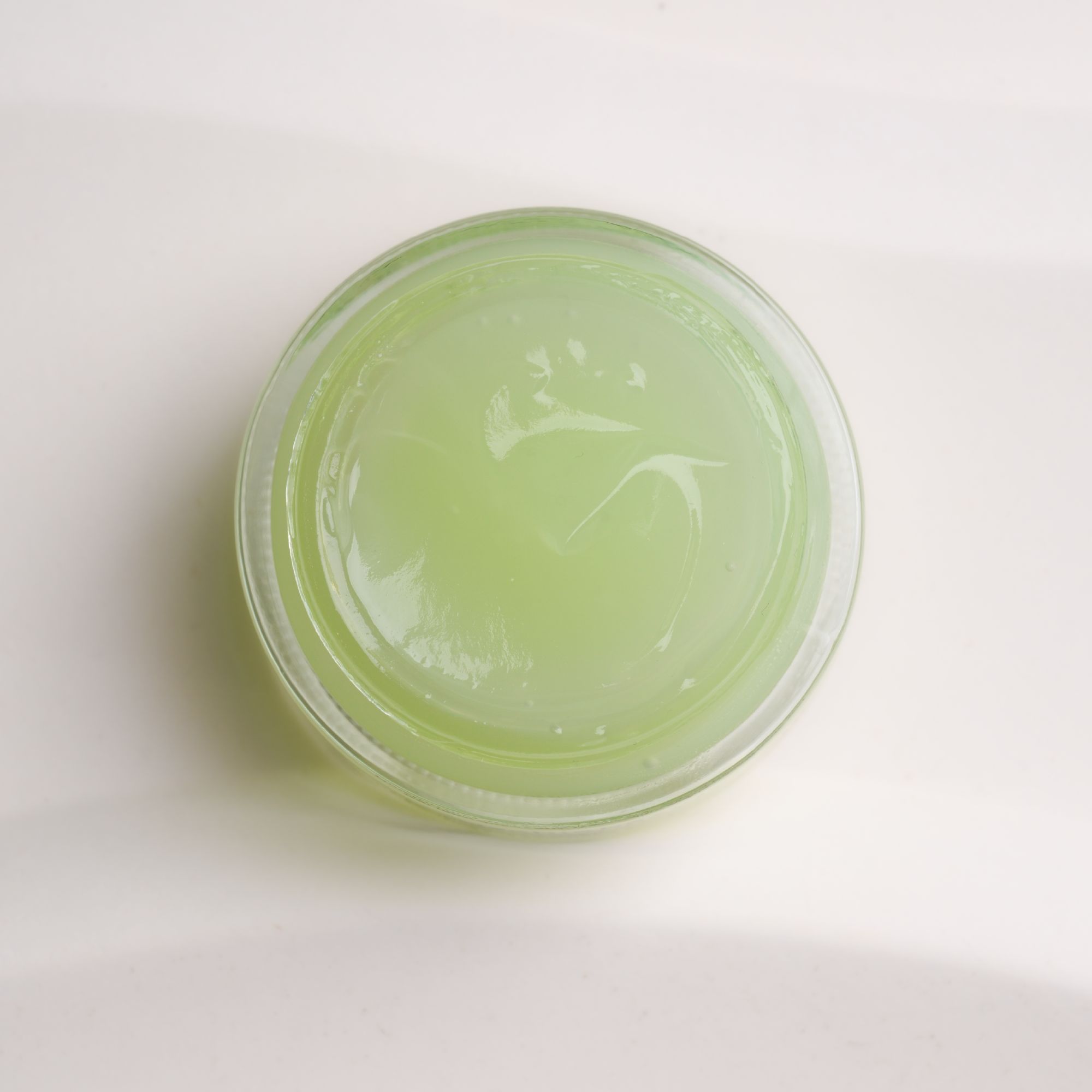 Grünes Gel in einem transparenten Glasbehälter. Draufsicht.