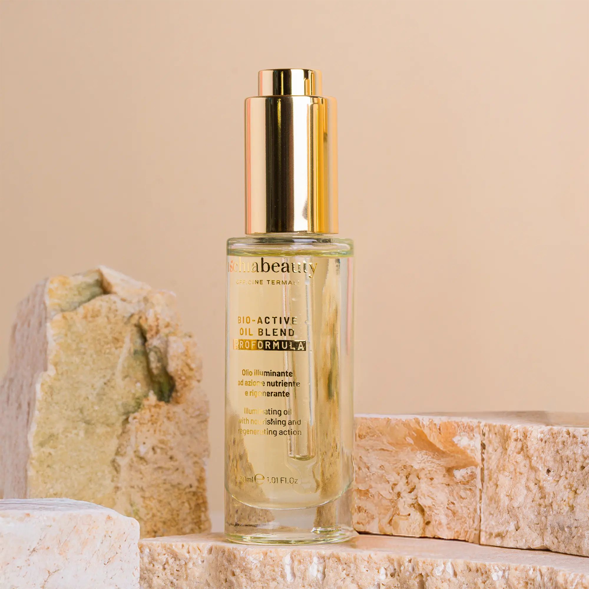 Glasflasche mit goldfarbenem Verschluss. Aufschrift: ischiabeauty, BIO-ACTIVI OIL BLEND. Klarer Inhalt, platziert auf Steinblöcken.