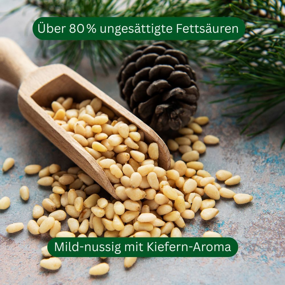 Hölzerner Löffel mit Pinienkernen. Kiefernzapfen und grüne Zweige. Text: "Über 80% ungesättigte Fettsäuren".