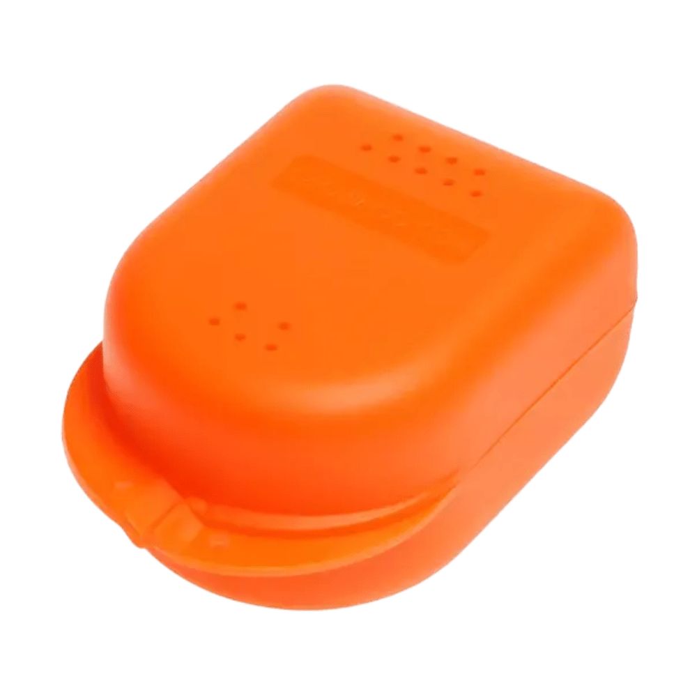 Orangefarbene Zahnspangenbox mit abgerundeten Ecken. Deckel mit kleinen Löchern und erhabenem Rechteck. Griff an der Unterseite.