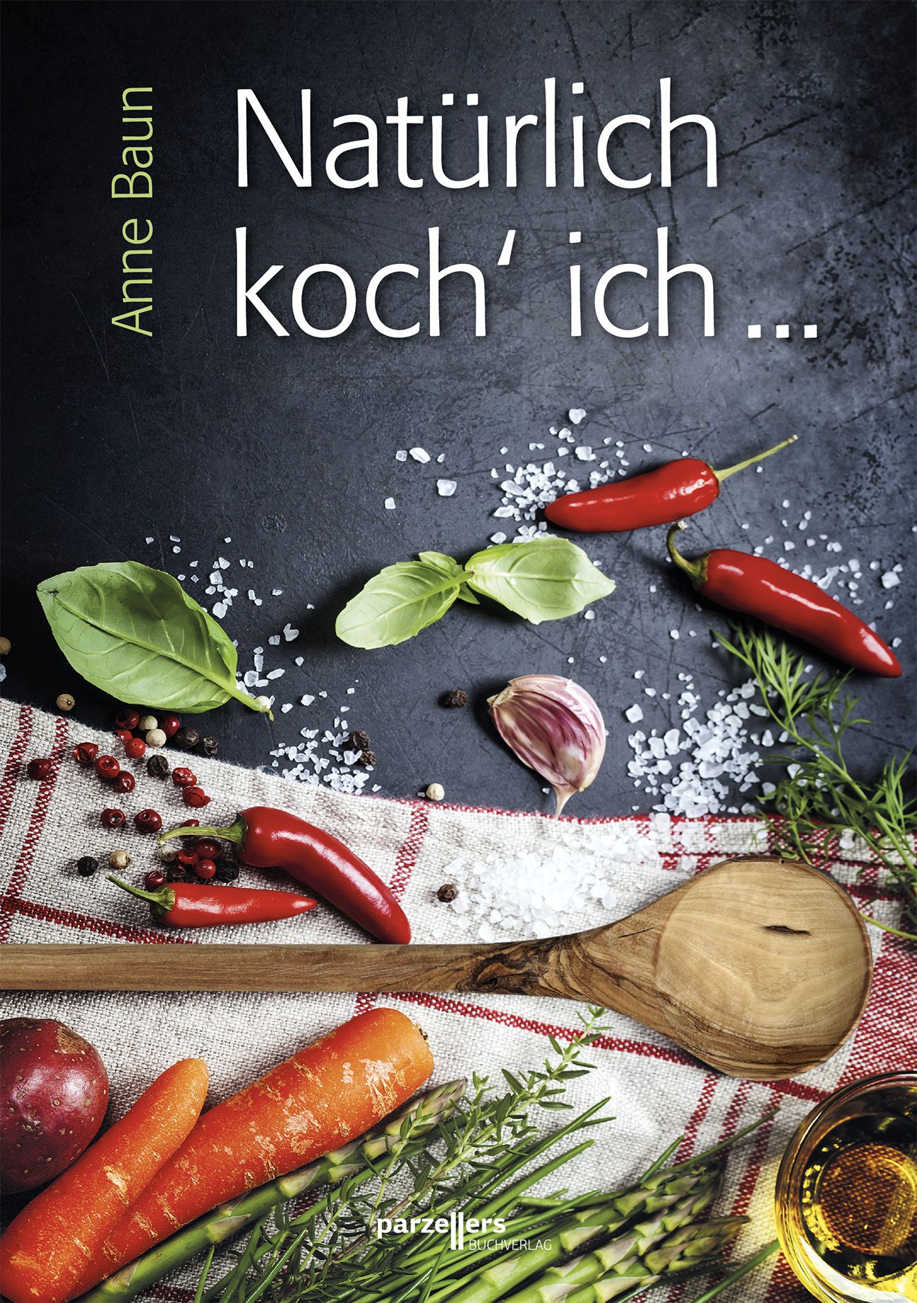 Buchcover mit Titel "Natürlich koch' ich ..." von Anne Baun. Auf dunklem Hintergrund: Gemüse, Kräuter, Salz, Chilischoten und ein Holzlöffel.