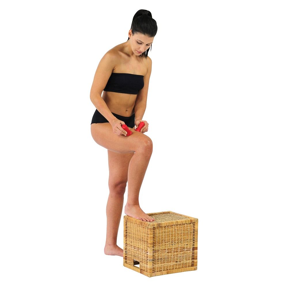 Frau verwendet Schröpfköpfe an ihrem Bein. Sie steht auf einem Korb. Rote Schröpfköpfe.