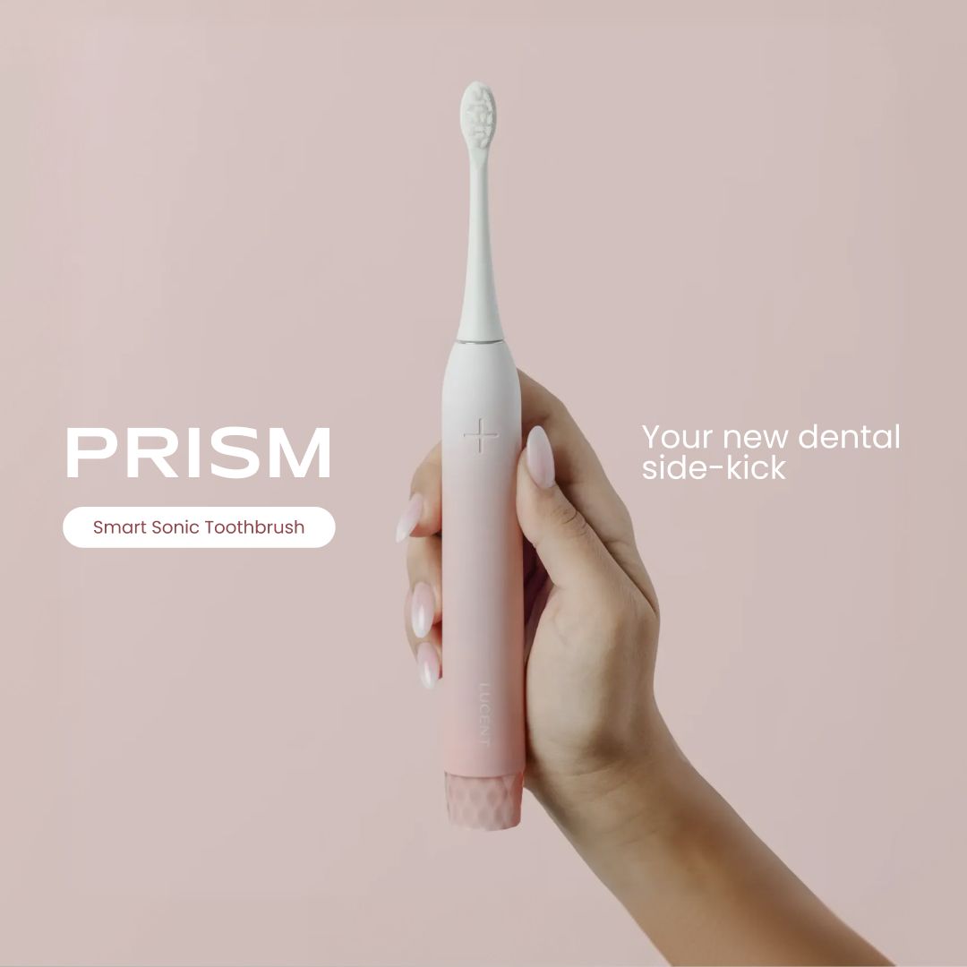 Be Lucent Prism Sonic Elektrische Zahnbürste in Rosa, gehalten von einer Hand.