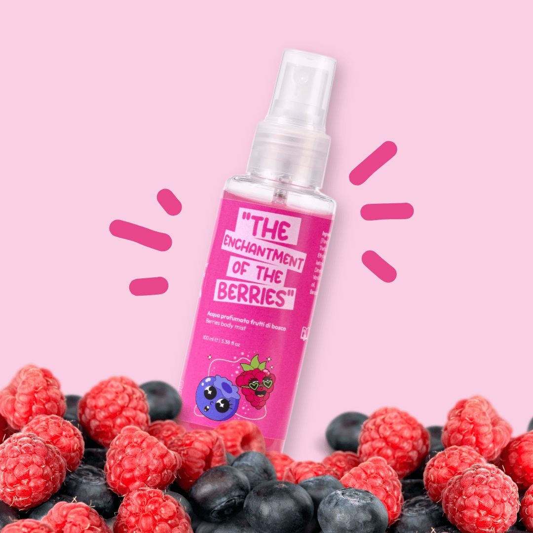 Flacone rosa con vaporizzatore contenente un liquido trasparente. L'etichetta recita "THE ENCHANTMENT OF THE BERRIES" con illustrazioni di mirtilli e lamponi. La bottiglia è circondata da bacche.