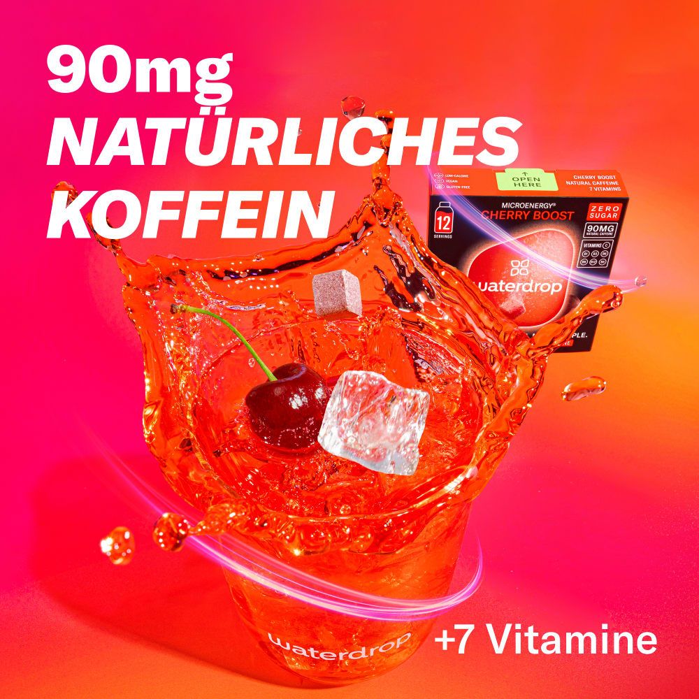 Getränk mit Kirschen, Eiswürfeln und Produktverpackung. Aufschrift: Microenergy Cherry Boost, 12 Portionen, ohne Zucker, 90mg, Koffein.