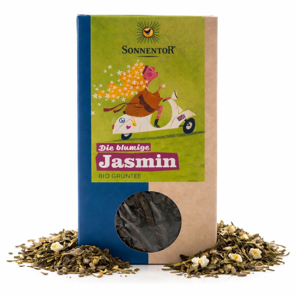Sonnentore Jasmin Bio Grüntee lose, umgeben von Tee und Blüten, neben der Verpackung.