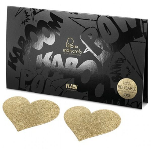 Zwei goldene Herz-Aufkleber mit Glitzer, vor einer schwarzen Verpackung mit Comic-Aufdruck.