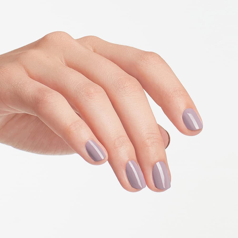 Hand mit hellviolett lackierten Fingernägeln. Nahaufnahme, helle Haut.