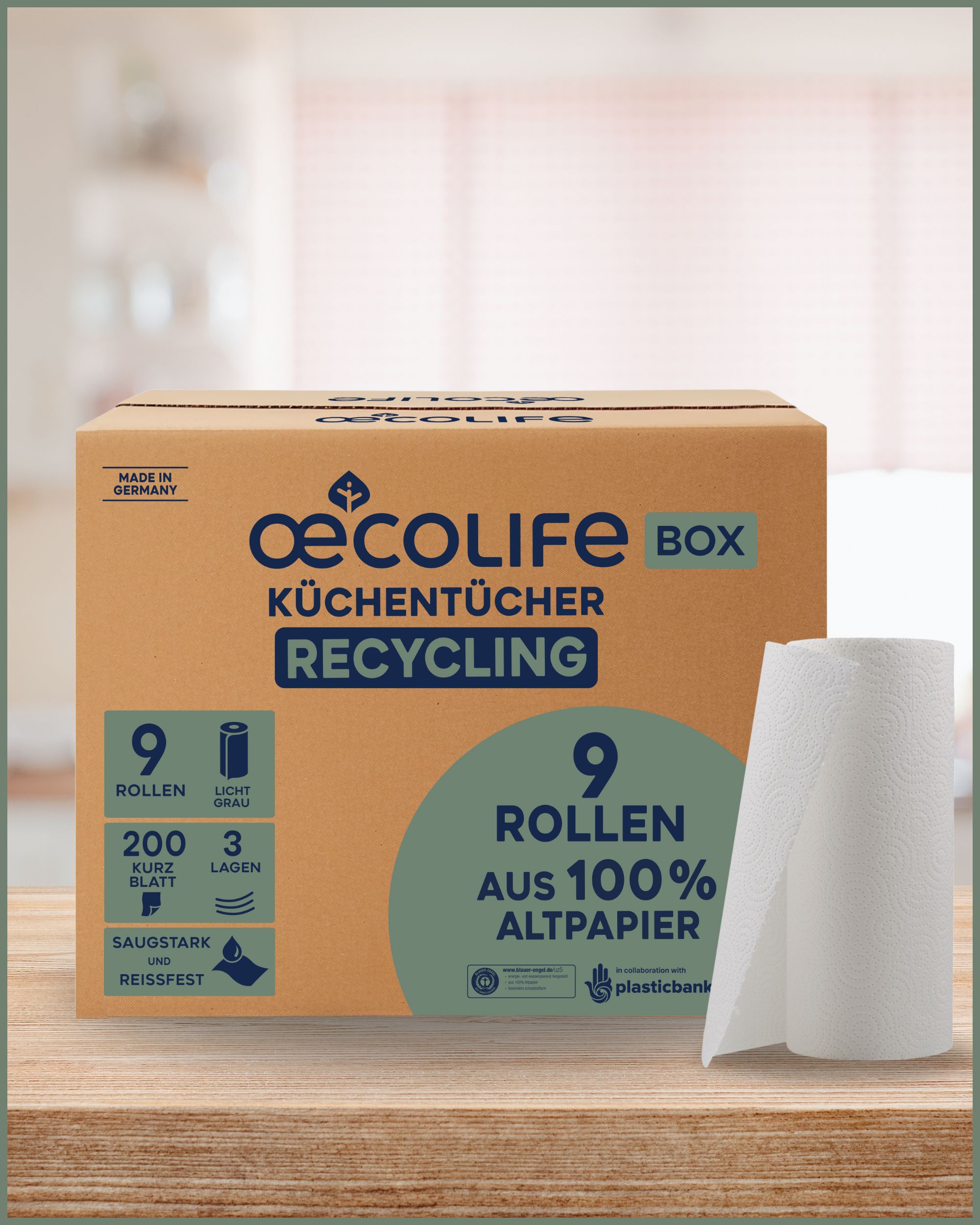 Kartonbox mit 9 Rollen oecolife Küchentücher RECYCLING. 200 Blatt, 3 Lagen, aus 100% Altpapier. Rolle Küchentücher daneben.
