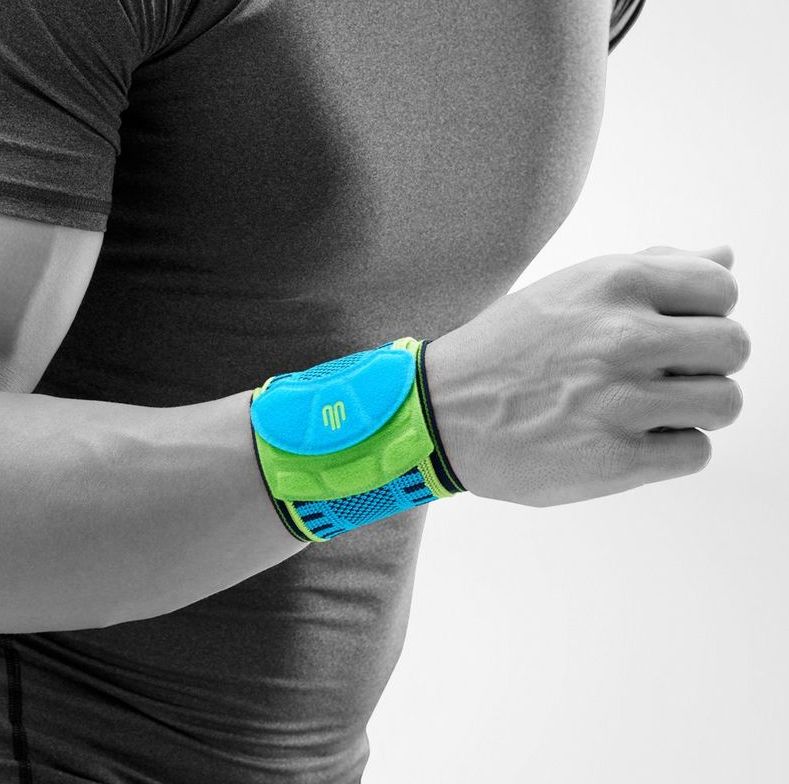 Person mit Handgelenkbandage. Blaue, grüne und schwarze Bandage am Handgelenk.
