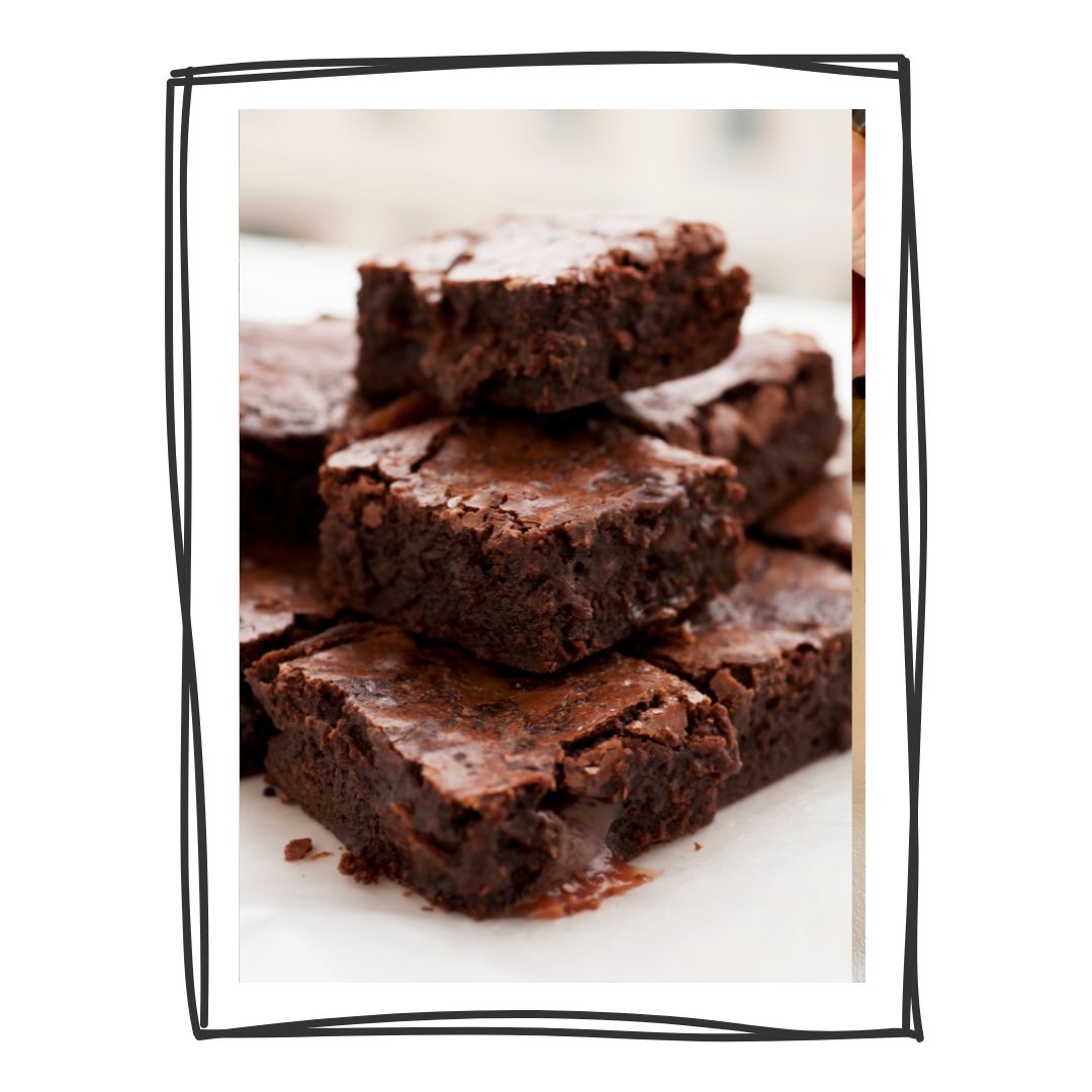 Braune Brownies, gestapelt. Auf weißem Teller, umrandet von schwarzem Rahmen.