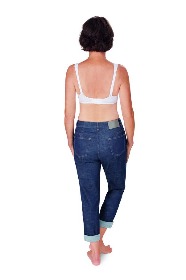 Rückansicht einer Frau in Jeans und weißem BH. Der BH hat breite Träger. Barfuß.