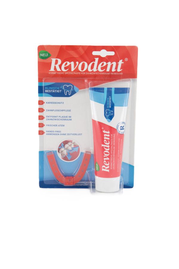 Zahnpflege-Set mit Tube und Mundstück. Tube mit roter und blauer Beschriftung. Mundstück rot.