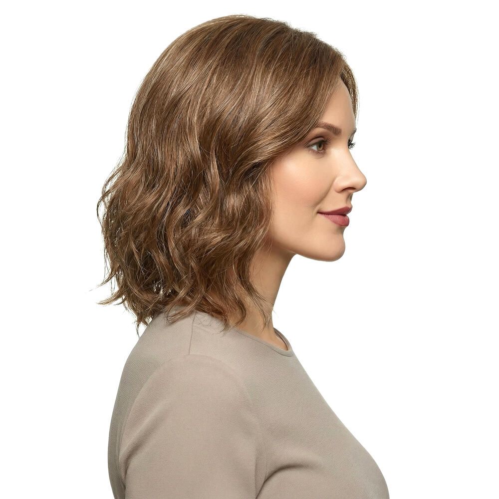 Perücke Lilie von trendhair. Kurze, gewellte, braune Haare. Frau mit beigem Oberteil. Seitenansicht.