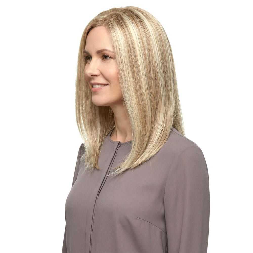 Blond gefärbte Perücke mit schulterlangem, glattem Haar. Die Frau trägt ein graues Oberteil.