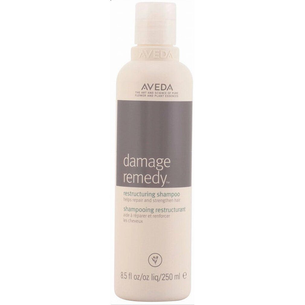 Beige Shampoo-Flasche mit grauem Etikett. Aufschrift: Aveda, Damage Remedy, Restructuring Shampoo. 250 ml.
