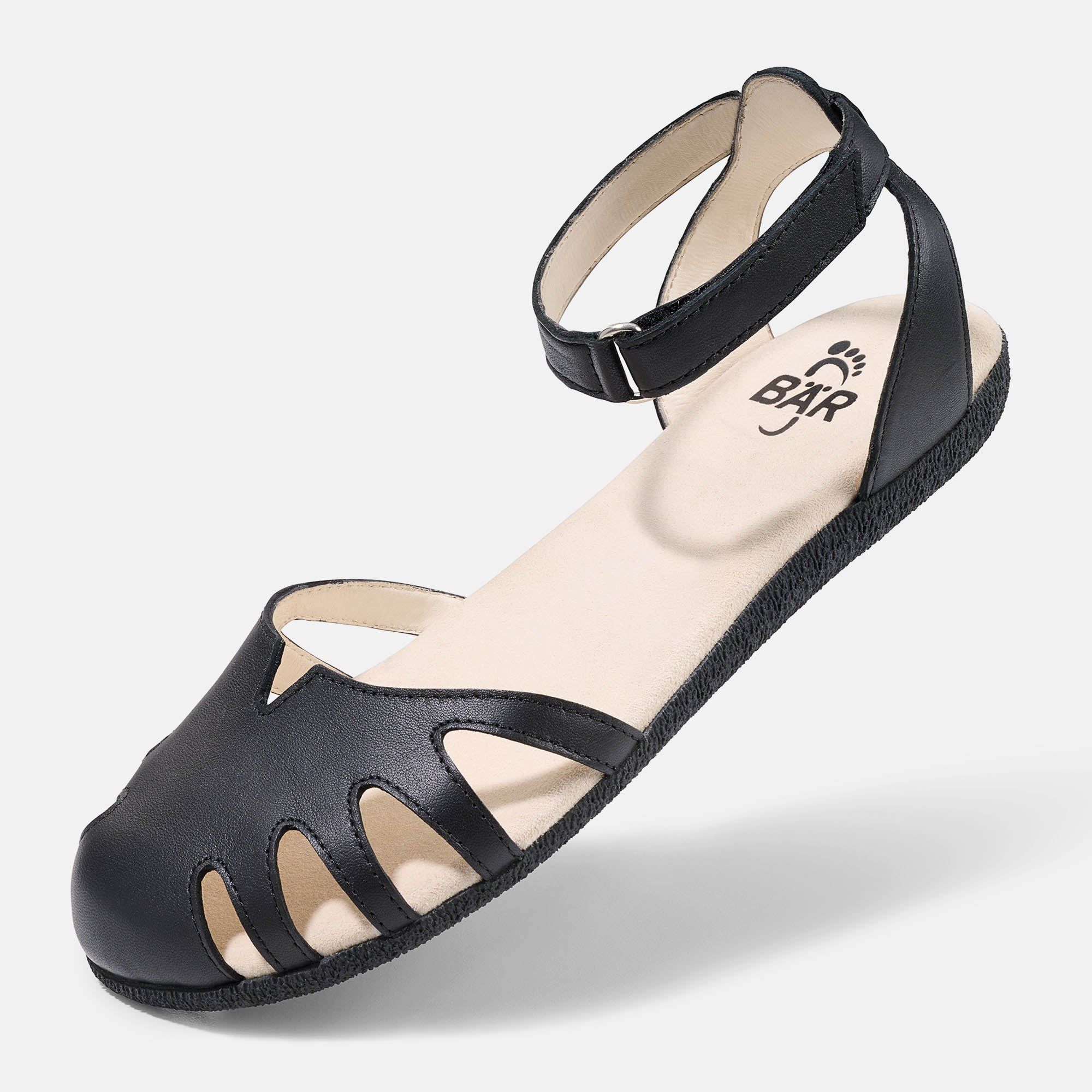 Schwarze Sandale mit Riemen und Aussparungen. Innensohle hell. Marke BÄR. Schuh leicht schräg.