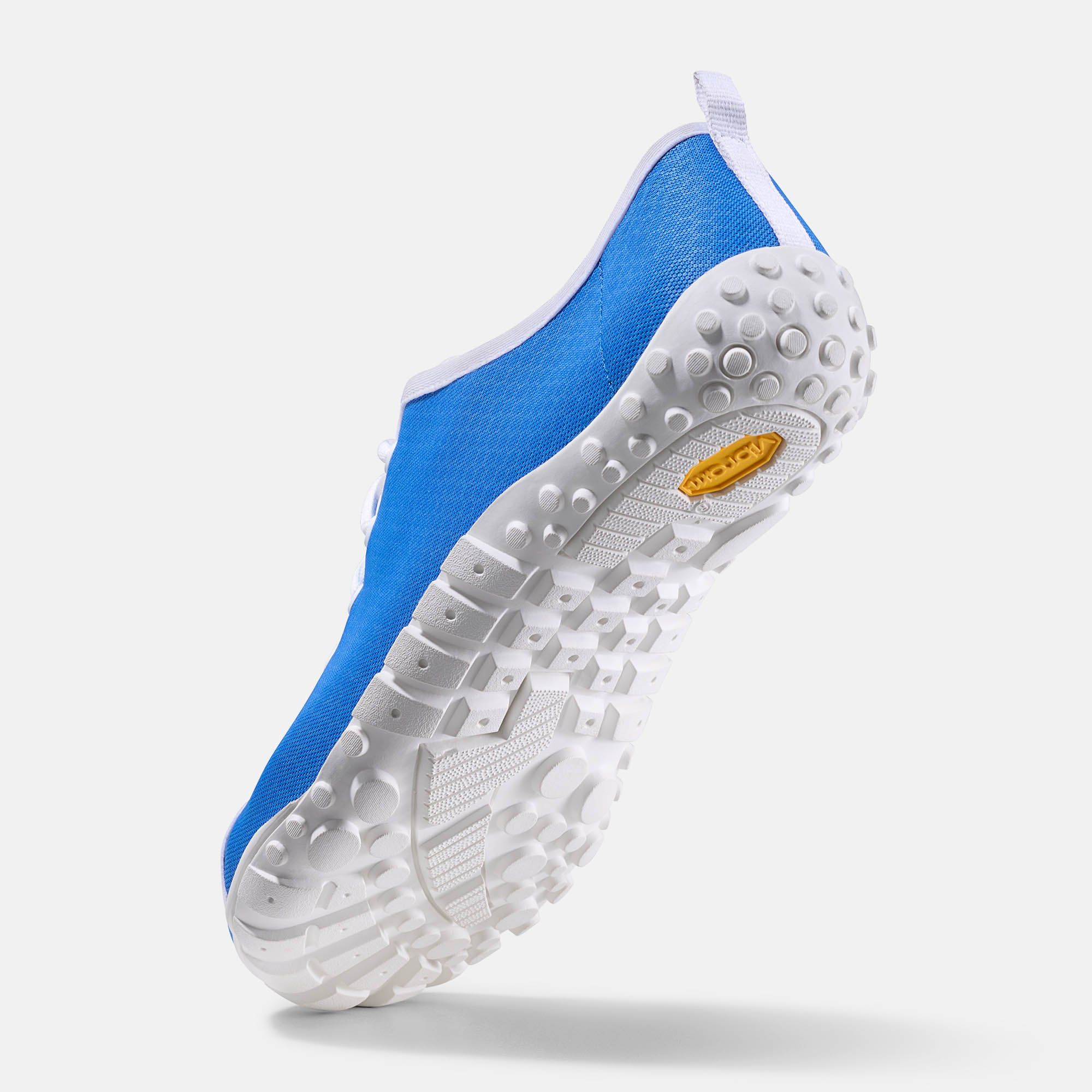 Herren-Schnürschuh, blaue Textiloberfläche mit Wabenmuster. Weiße Sohle mit Profil und gelbem Logo. Breiter Schnitt.