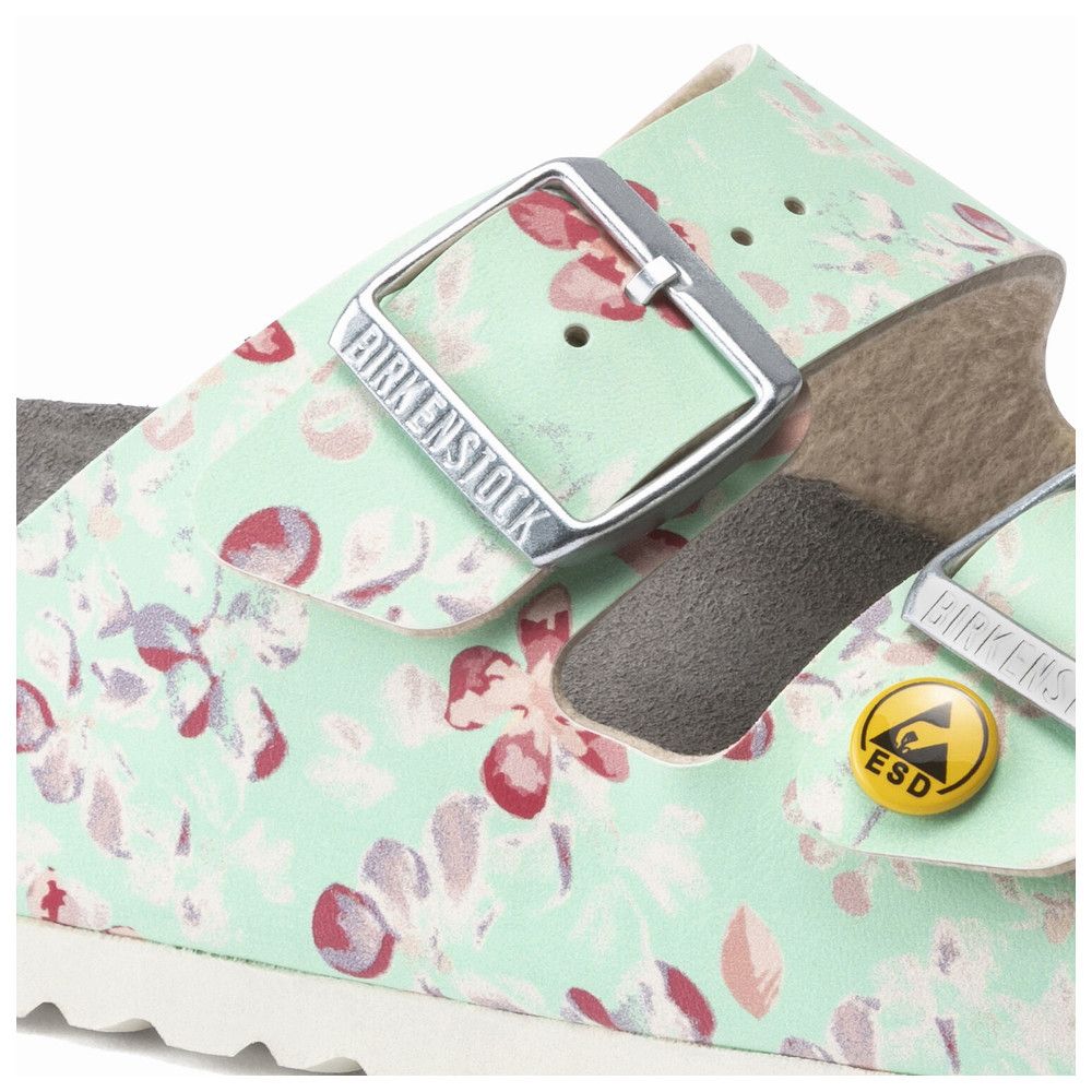 Detailansicht einer türkisfarbenen Sandale mit Blumenmuster, Schnalle mit Logo, ESD-Zeichen.